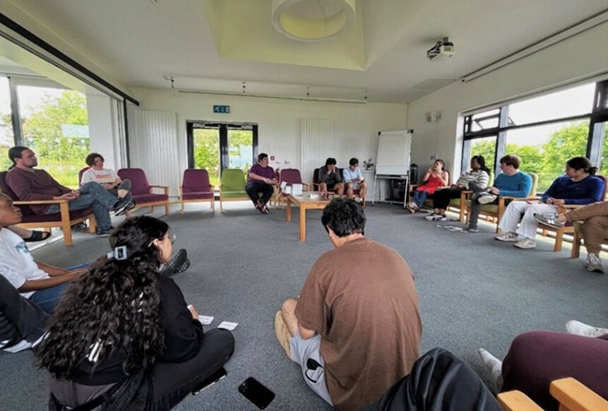 All participants gather in a circle, sharing their thoughts and learnings.