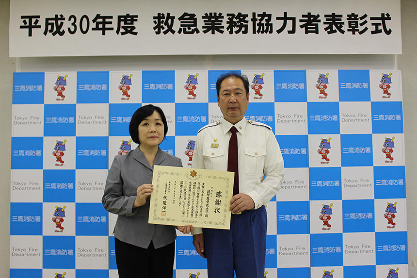 三鷹消防署長より感謝状を受け取った畠山珠美本学事務局長(写真左)